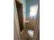 This bathroom features a toilet, small sink, a walk-in shower, tiled walls, and a patterned tile floor at 18133 Us Highway 41, Spring Hill, FL 34610