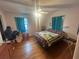 Cozy bedroom with wood floors, featuring a bed with a quilt and teal curtains at 18133 Us Highway 41, Spring Hill, FL 34610