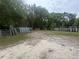A broad view reveals a property featuring metal gates and fencing materials across a light sand and grass landscape at 18133 Us Highway 41, Spring Hill, FL 34610