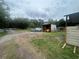 Large gravel and grass lot featuring a metal storage shed and construction equipment under a cloudy sky at 18133 Us Highway 41, Spring Hill, FL 34610