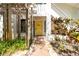 Charming entryway with a bright yellow door, brick walkway, and pergola, creating a welcoming facade at 1854 Lake Cypress Dr # 1854, Safety Harbor, FL 34695