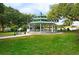 This image showcases a picturesque gazebo nestled in a lush green lawn with mature trees, offering a serene outdoor space at 1854 Lake Cypress Dr # 1854, Safety Harbor, FL 34695