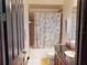 Traditional bathroom with a shower-tub combo, vanity sink, neutral tile, and seashell patterned curtain at 20023 Pergola Bend Ln, Tampa, FL 33647