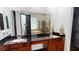 Bathroom showcasing double sinks, wood cabinetry, a large mirror, and a view of the soaking tub and shower at 20023 Pergola Bend Ln, Tampa, FL 33647