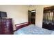 Bedroom showcasing a large dresser, a dark wooden door, and a patterned bedspread at 20023 Pergola Bend Ln, Tampa, FL 33647