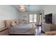 Well lit bedroom featuring hardwood flooring, an upholstered bed and modern light fixture at 20023 Pergola Bend Ln, Tampa, FL 33647