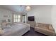 Well lit bedroom featuring hardwood flooring, an upholstered bed and modern light fixture at 20023 Pergola Bend Ln, Tampa, FL 33647