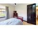 Bedroom with a dark wooden door and a matching dresser with a TV set at 20023 Pergola Bend Ln, Tampa, FL 33647