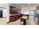 Spacious kitchen featuring dark wood cabinetry, an island with granite counters, and stainless steel appliances at 20023 Pergola Bend Ln, Tampa, FL 33647
