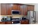 Kitchen with granite countertops, stainless steel appliances, and custom dark wood cabinetry at 20023 Pergola Bend Ln, Tampa, FL 33647