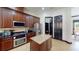 Kitchen with granite countertops, center island, stainless appliances, and dark wood cabinetry at 20023 Pergola Bend Ln, Tampa, FL 33647