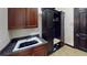 Functional laundry room with sink, storage, built-in bench, and a black entry door at 20023 Pergola Bend Ln, Tampa, FL 33647