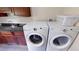Well-equipped laundry room with modern appliances, ample counter space, and custom wood cabinetry at 20023 Pergola Bend Ln, Tampa, FL 33647