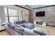 Inviting living room with a large sectional and view of TV mounted above a modern fireplace at 20023 Pergola Bend Ln, Tampa, FL 33647