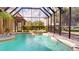 Relaxing screened-in pool area features a spa, lush landscaping, and a serene atmosphere at 20023 Pergola Bend Ln, Tampa, FL 33647