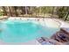Serene screened-in pool area with a spa, rock waterfall, and lush landscaping at 20023 Pergola Bend Ln, Tampa, FL 33647