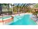 Inviting screened-in pool and spa area surrounded by lush landscaping and a covered lanai at 20023 Pergola Bend Ln, Tampa, FL 33647