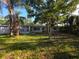 Backyard view showcasing the home's exterior with large trees and a screened-in porch at 2045 Summit Dr, Dunedin, FL 34698