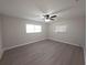 Bright bedroom featuring two windows, ceiling fan, and updated flooring at 2045 Summit Dr, Dunedin, FL 34698