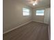 Light bedroom featuring two windows, ceiling fan, neutral walls, and updated flooring at 2045 Summit Dr, Dunedin, FL 34698
