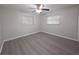 Neutral bedroom featuring updated flooring, two windows, and base trim at 2045 Summit Dr, Dunedin, FL 34698
