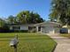 Charming single-story home with a well-maintained lawn and lush greenery at 2045 Summit Dr, Dunedin, FL 34698