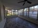 Enclosed sunroom with gray wood floors and large windows overlooking the backyard at 2045 Summit Dr, Dunedin, FL 34698
