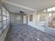 Bright sunroom featuring tile accent wall, modern ceiling fan, and durable gray wood-look flooring at 2045 Summit Dr, Dunedin, FL 34698