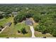 Expansive aerial view of a home with lush surrounding greenery and a long driveway, plus a screened in pool at 25238 Bunting Cir, Land O Lakes, FL 34639