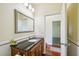 Bathroom featuring a wood vanity with black countertop, a decorative mirror, and great lighting at 25238 Bunting Cir, Land O Lakes, FL 34639