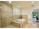 Bathroom featuring a glass enclosed shower with soaking tub and tile surround at 25238 Bunting Cir, Land O Lakes, FL 34639
