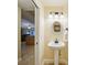 A small powder room featuring a pedestal sink, an oval mirror, and modern lighting at 25238 Bunting Cir, Land O Lakes, FL 34639