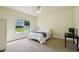 Bright bedroom featuring a ceiling fan, a desk, and a window providing view of the lush outdoor space at 25238 Bunting Cir, Land O Lakes, FL 34639