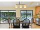 Dining space with a view of the pool, features a modern light fixture and stylish chairs for comfortable dining at 25238 Bunting Cir, Land O Lakes, FL 34639