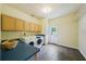 Spacious laundry room featuring tile floors, wood cabinets, utility sink, and washer and dryer at 25238 Bunting Cir, Land O Lakes, FL 34639