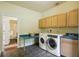 Functional laundry room features modern appliances, a utility sink, and overhead cabinets for storage at 25238 Bunting Cir, Land O Lakes, FL 34639