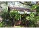Charming cabin exterior featuring a brown facade surrounded by lush greenery and mature trees at 260 Orange St, Palm Harbor, FL 34683