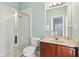 Well-lit bathroom features a glass shower door, white tile, and a vanity with light countertops at 27209 Firebush Dr, Wesley Chapel, FL 33544