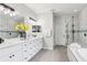 Bright bathroom featuring a double sink vanity, modern fixtures, shower, and separate soaking tub at 27209 Firebush Dr, Wesley Chapel, FL 33544
