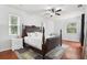 A well-lit bedroom with a wooden bed frame, white walls, and hardwood floors at 27209 Firebush Dr, Wesley Chapel, FL 33544