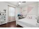 Bright bedroom featuring colorful geometric wall art and wood flooring at 27209 Firebush Dr, Wesley Chapel, FL 33544