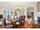 Elegant dining room with wood floors, archways, chandelier lighting, with seating for six at 27209 Firebush Dr, Wesley Chapel, FL 33544