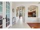 Inviting home hallway with decorative archways and tiled flooring leading to other rooms at 27209 Firebush Dr, Wesley Chapel, FL 33544