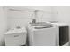 Bright laundry room includes a utility sink, washer and dryer hookups, and wire shelving at 27209 Firebush Dr, Wesley Chapel, FL 33544