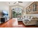 Living room with a large window, wood floors, and a decorative wall at 27209 Firebush Dr, Wesley Chapel, FL 33544