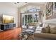 Bright living room with wood floors, a decorative wall, and large windows overlooking a beautiful view at 27209 Firebush Dr, Wesley Chapel, FL 33544
