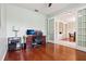 Bright office with a large desk, wood floors, and glass paneled doors at 27209 Firebush Dr, Wesley Chapel, FL 33544