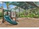 Community playground with a slide, swings, and shade covering, offering a fun and safe play area at 27209 Firebush Dr, Wesley Chapel, FL 33544