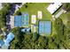 Aerial view showing tennis and pickleball courts, with verdant landscaping and a neighborhood backdrop at 28390 Openfield Loop, Wesley Chapel, FL 33543