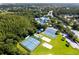 An aerial view shows tennis and pickleball courts with mature trees and landscaping in the community at 28390 Openfield Loop, Wesley Chapel, FL 33543